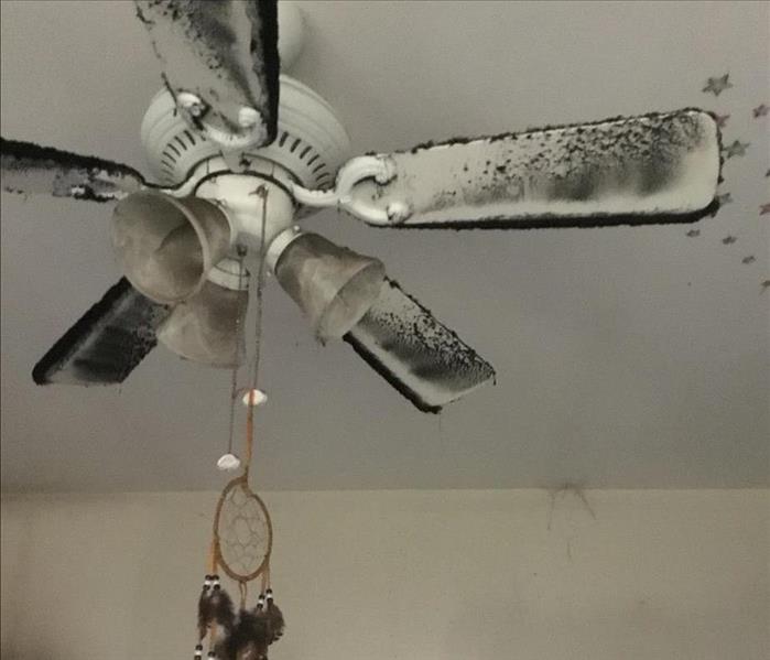 Ceiling fan covered in smoke soot and dust
