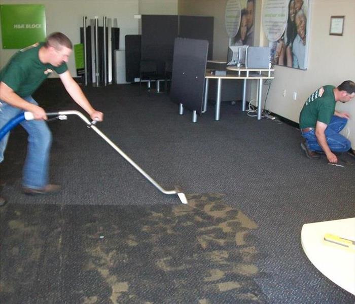 Servpro guys vacuuming watery/muddy carpet